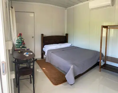 a bedroom with a bed and a christmas tree at Kite Bungalow Bahia Salinas in La Cruz