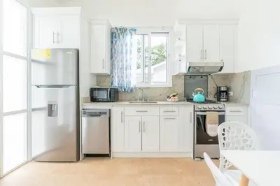 a kitchen with white cabinets and a stainless steel refrigerator at Casa Blue Monkey - Playa Conchal in Brasilito