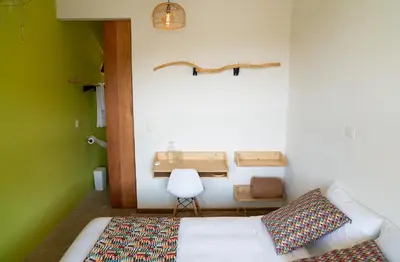 a bedroom with a bed and a table and a chair at Hotel con Corazon Monteverde in Monteverde Costa Rica