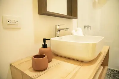 a bathroom with a white sink on a wooden counter at Hotel con Corazon Monteverde in Monteverde Costa Rica