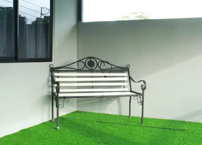 a bench sitting on the grass next to a building at Berakah Apartment in Fortuna