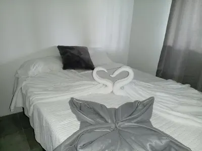 a bed with two white swans forming a heart at Berakah Apartment in Fortuna