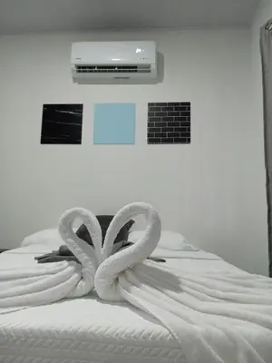 a white bed with two towel snakes on it at Berakah Apartment in Fortuna