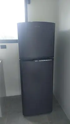 a black refrigerator in the corner of a room at Berakah Apartment in Fortuna