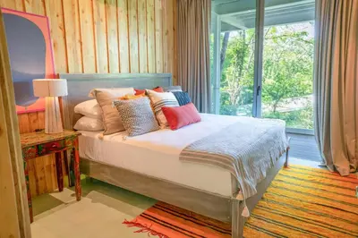 a bedroom with a bed with pillows and a window at Casa AguasPoolYoga deckwalk to Surf Point in Santa Teresa Beach