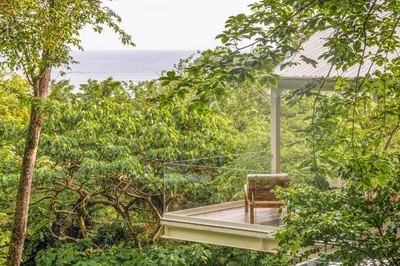 a chair sitting on a porch looking out at the ocean at Casa AguasPoolYoga deckwalk to Surf Point in Santa Teresa Beach
