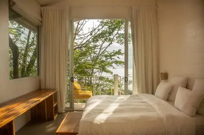 a bedroom with a bed and a large window at Casa Aliki, Luxury Beach Home with THE VIEW in Santa Teresa Beach