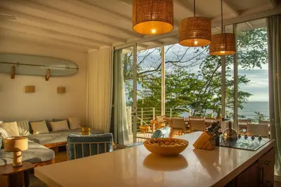 a living room with a table with a bowl of fruit on it at Casa Aliki, Luxury Beach Home with THE VIEW in Santa Teresa Beach