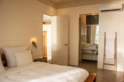 a bedroom with a white bed and a sink at Casa Aliki, Luxury Beach Home with THE VIEW in Santa Teresa Beach