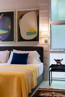 a bedroom with a bed with a yellow blanket at Bamboo Bungalow in Santa Teresa Beach
