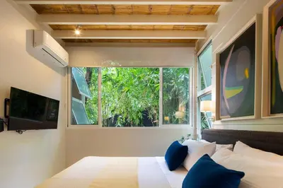 a bedroom with a bed and a large window at Bamboo Bungalow in Santa Teresa Beach