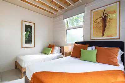a bedroom with two beds and a window at Bamboo Bungalow in Santa Teresa Beach