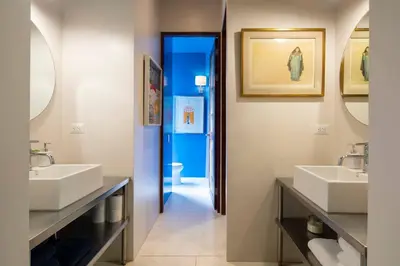 a bathroom with two sinks and two mirrors at Bamboo Bungalow in Santa Teresa Beach