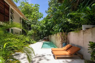 a swimming pool with a couch next to a house at Bamboo Bungalow in Santa Teresa Beach