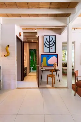 a living room with a table and a painting on the wall at MAR A MAR Nest Bungalow - Pool WalkTo Beach in Santa Teresa Beach