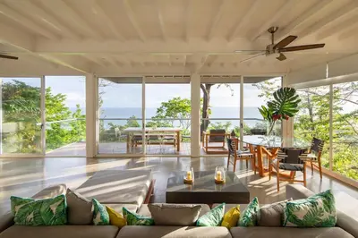 a living room with a couch and a table at Casa AtrapasueñosEpic View Surfer's Paradise in Santa Teresa Beach