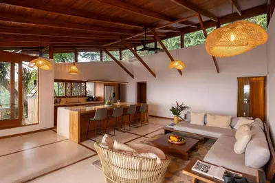 a living room with a couch and a kitchen at Casa RicaSunset ocean view pool fiber optic in Cóbano