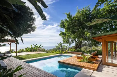 a swimming pool with a deck and a house at Casa RicaSunset ocean view pool fiber optic in Cóbano