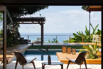 a patio with chairs and a swimming pool with the ocean at Casa RicaSunset ocean view pool fiber optic in Cóbano