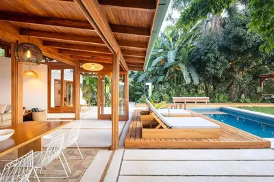 an outdoor dining area with a pool and a house at Casa RicaSunset ocean view pool fiber optic in Cóbano