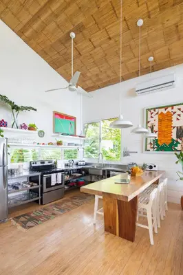a large kitchen with a wooden table and a dining room at Casazul - Tropical escape ocean views in Santa Teresa Beach