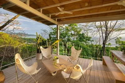 a patio with a table and chairs on a deck at Casazul - Tropical escape ocean views in Santa Teresa Beach