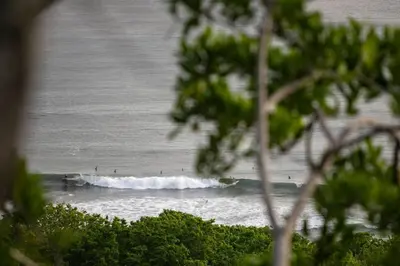 a group of surfers riding the waves in the ocean at Casazul - Tropical escape ocean views in Santa Teresa Beach