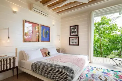 a bedroom with a bed and a window at Casazul - Tropical escape ocean views in Santa Teresa Beach