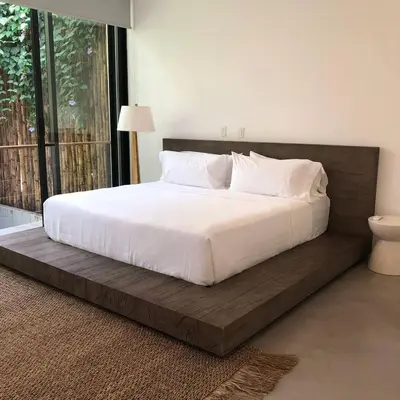 a large bed with a wooden frame in a bedroom at Naia Surf VillasWalk to Beach 2 Private Pools in Santa Teresa Beach