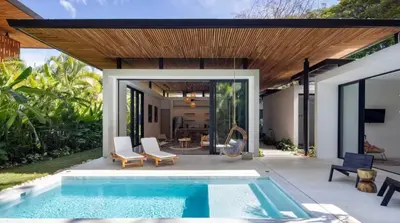 a patio with a swimming pool and a house at Naia Surf VillasWalk to Beach 2 Private Pools in Santa Teresa Beach