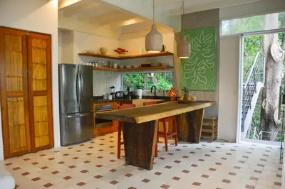 a kitchen with a large wooden counter top and a refrigerator at Tree NestNido 2- Ocean view- 5 min walk to beac in Santa Teresa Beach