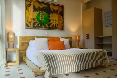 a bedroom with a bed with orange and white pillows at Tree NestNido 2- Ocean view- 5 min walk to beac in Santa Teresa Beach