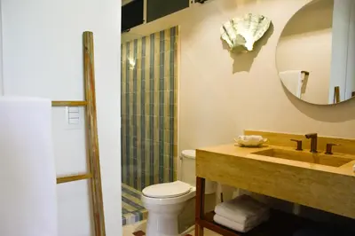 a bathroom with a sink and a toilet and a mirror at Tree NestNido 2- Ocean view- 5 min walk to beac in Santa Teresa Beach