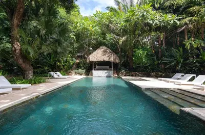 a swimming pool in a resort with chairs and trees at Tree NestNido 2- Ocean view- 5 min walk to beac in Santa Teresa Beach