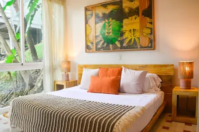 a bedroom with a bed and a large window at Tree NestNido 2- Ocean view- 5 min walk to beac in Santa Teresa Beach