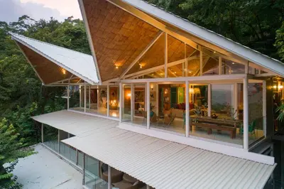a house with glass windows and a roof at Nido del Mar - Art-Filled Beach house in Santa Teresa