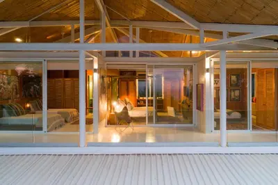 a house with large glass windows and a bedroom at Nido del Mar - Art-Filled Beach house in Santa Teresa