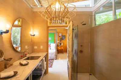 a bathroom with a sink and a chandelier at Nido del Mar - Art-Filled Beach house in Santa Teresa
