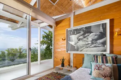 a living room with a couch and a large window at Nido del Mar - Art-Filled Beach house in Santa Teresa