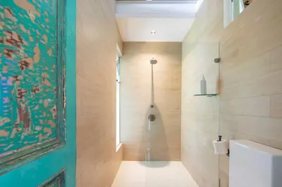 a bathroom with a shower with a glass door at Nido del Mar - Art-Filled Beach house in Santa Teresa