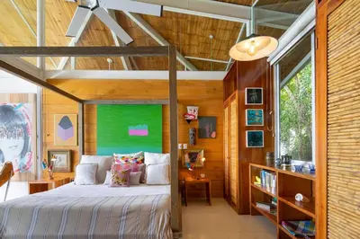 a bedroom with a bed and a green wall at Nido del Mar - Art-Filled Beach house in Santa Teresa