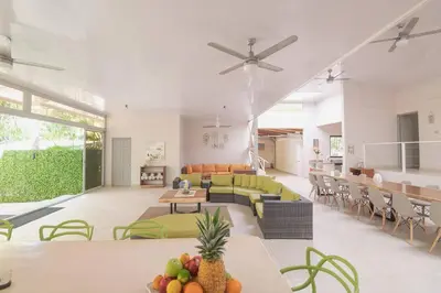 a living room with a couch and tables and chairs at Luxury Beachfront VillaBest Surf Spot in Santa Teresa Beach