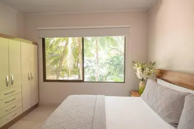 a bedroom with a white bed and a window at Luxury Beachfront VillaBest Surf Spot in Santa Teresa Beach