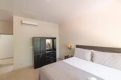a bedroom with a bed and a cabinet with flowers at Luxury Beachfront VillaBest Surf Spot in Santa Teresa Beach