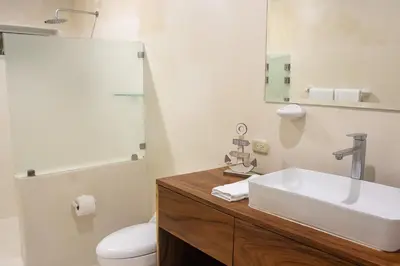 a bathroom with a sink and a toilet and a mirror at Luxury Beachfront VillaBest Surf Spot in Santa Teresa Beach