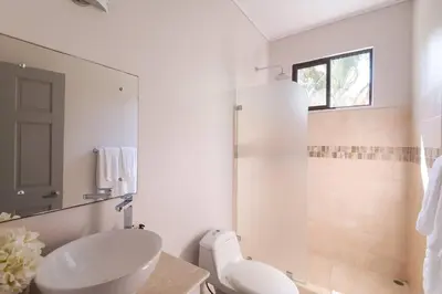a white bathroom with a sink and a shower at Luxury Beachfront VillaBest Surf Spot in Santa Teresa Beach