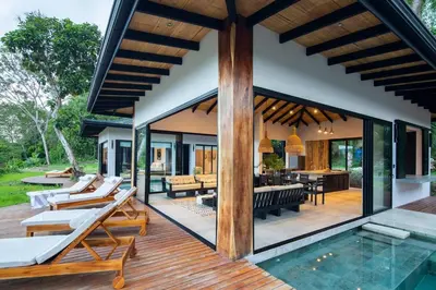 an outdoor deck with a pool and a house at Villa Ayla - Santa Teresa Minutes from the beach in Carmen
