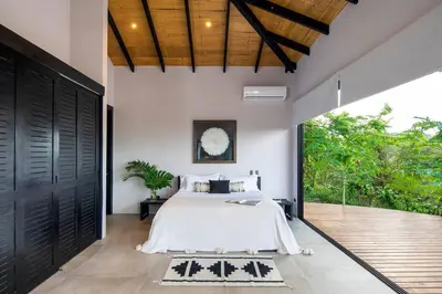 a bedroom with a bed and a large door at Villa Ayla - Santa Teresa Minutes from the beach in Carmen