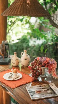 a table with vases and cups and a bunch of grapes at Surf Casitas - High Tide Bungalow in Santa Teresa Beach