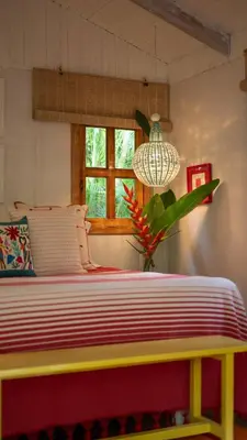 a bedroom with a yellow and red bed with a window at Surf Casitas - Mid Tide Bungalow in Santa Teresa Beach